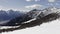 winter aerial over group of people with snowshoes hiking down a snowy slope. Winter wonderland panorama with active