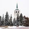 Winter alley in park and an Orthodox church spire. The bell tower of the Orthodox Church