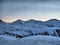 A winter alpine mountain scene under a blue sky