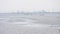 Winter anglers on ice of frozen water storage basin on background of hydroelectric power plant