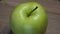 A winter apple variety known as Reinette Simirenko. One green apple close-up. The Reinette Simirenko is an antique apple variety.
