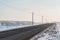 Winter background. A road with net poles at the edges