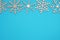 Winter background with snowflakes. Wooden laser cut snowflakes on the top on blue background.