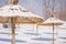 Winter on the beach with frozen snow on the sand and parasol