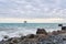 Winter beach with seascape and a rickety structure on the stilts of an aquaculture farm in the distance