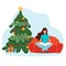 Winter break season. A beautiful girl is sitting on the couch and reading a book. New Year s and Christmas