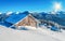 Winter cabins under blue sky in snowy mountains