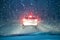 Winter car night driving. snowfall traffic. car silhouette seen through snowy and wet windscreen