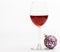 Winter celebration with alcohol drink. New year party concept. Wineglass with red liquid or wine and christmas ball