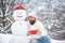 Winter chef cook. Bearded chef with snowman cook at sunny day in the winter park. Funny winter Greeting Card with snow