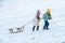 Winter children with sled. Active winter outdoors games. Happy Christmas vacation concept.