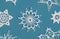 Winter or Christmas background. Crochet snowflakes isolated on light blue. Handmade decorative knitted napkin snowflake