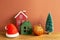 Winter christmas concept. Santa claus hat, house model, bauble, tree on wooden table