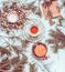 Winter and Christmas lifestyle. Woman hand holding tea pot on white knitted blanket with cup of tea, Christmas wreath and fir