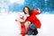 Winter, christmas, technology and people concept - woman and dog having fun takes selfie portrait on the smartphone