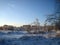 In winter, the city Park, trees and shrubs are buried in snow at sunset on a clear frosty day. The branches of the trees bend