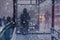 Winter city street and snow. Person standing alone. Blurred image of people
