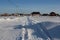 Winter cleared road travel among the snowdrifts in the winter in the Siberian village
