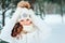 Winter close up portrait of cute dreamy child girl in white coat, hat and mittens