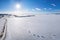 Winter coast, harbor and snow plain on the frozen sea at sunset