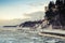 Winter coastal landscape with floating ice and frozen pier