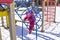 winter, cold, snow. little girl in metal rings at the playground