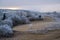 Winter coming. Picturesque pre sunrise scene above late autumn mountain countryside with hoarfrost on grasses, trees, slopes.