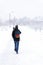 Winter is coming by snow. Poor visibility in heavy snow storm on path. Man slowly and hard walking in dangerous weather day.
