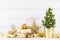 Winter composition with Christmas gift or present boxes, fir tree and golden holiday decorations on wooden background.