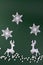 Winter composition with deers and snowflakes. On green background. Christmas card.