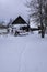 Winter in countryside. Snow civered old wooden buildings in country yard