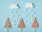 Winter creative sweet composition concept. Three hard caramel trees and falling marshmallow snow on pastel soft color background