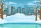 Winter day background. Frozen lake or river with snow covered leafless trees and bushes. Cityscape in the background