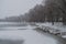 Winter day. River frozen - covered with ice and naked trees covered with white snow on there branches. Walking on nature