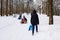 Winter day with snow and happy mother and doughter sleighing the