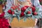 Winter decor. Beautiful flower arrangement of red roses, natural sprigs of blue spruce and Christmas berry holly or ilex twigs,