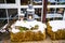 Winter decoration of yard made of haystacks, retro sleds and lanterns.