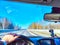 Winter Driving on winter or spring Snow Lined Road Under sunny blue Sky. Drivers perspective on snowy road with sun And