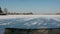 In winter drone flying down above snowy lake coast and boat, aerial