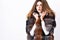 Winter elite luxury clothes. Female brown fur coat. Fur store model enjoy warm in soft fluffy coat with collar. Woman