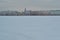 Winter embankment of Saint Petersburg with colorful neat buildings stands on banks of frozen Neva river in snow. European