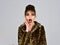 Winter fashion and beauty. Woman in leopard fur coat on grey background. Fur coat boutique with natural and artificial