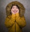 Winter fashion isolated portrait of young beautiful and happy Asian Korean woman in warm yellow feather jacket with fur hood