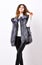 Winter fashionable wardrobe for female. Boutiques selling fur. Woman makeup face wear fur vest white background. Silver