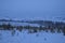 winter field in the snow valley with hills and fir trees forest frosty morning with fog