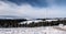 winter Fischbacher Alpen mountain range in Austria with wind turbines and higher peaks on the background