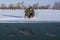 Winter fishing concept. Fisherman in action. Catching perch fish from snowy ice at lake above troop of fish. Double view under and