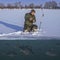 Winter fishing concept. Fisherman in action. Catching perch fish from snowy ice at lake above troop of fish. Double view under and