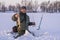 Winter fishing concept. Fisherman in action with trophy in hand. Catching pike fish from snowy ice at lake.