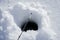 Winter fishing concept. Part of rod above hole in snowy ice at lake